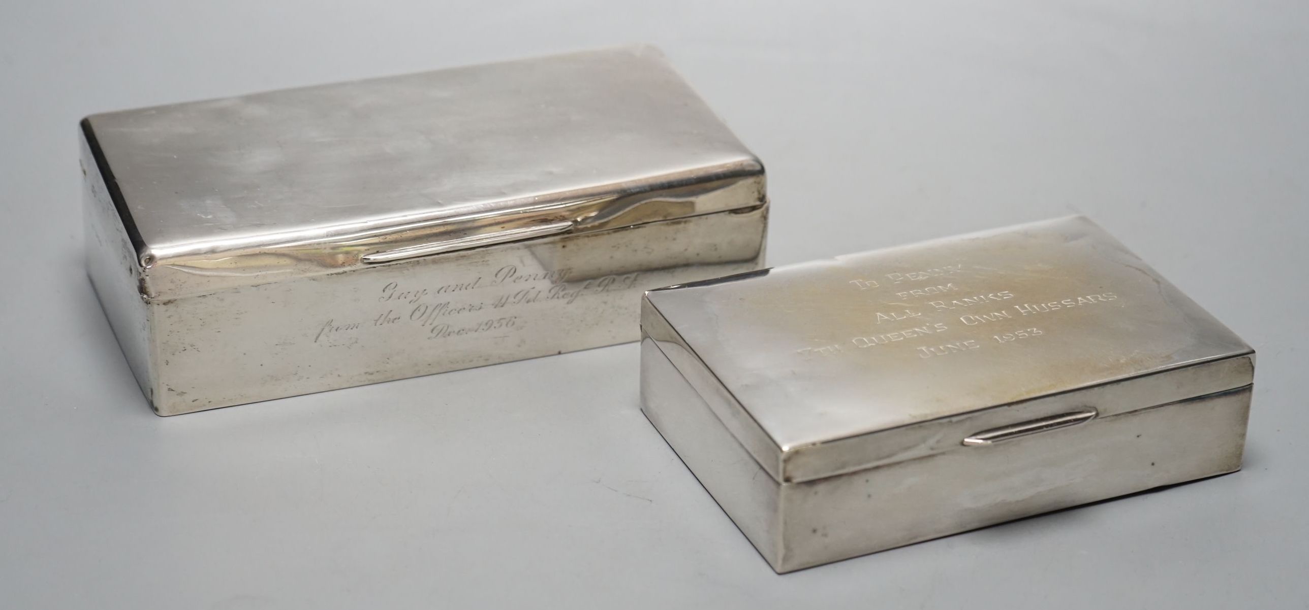 A 1950's silver mounted silver cigarette box, 18.2cm and a silver plated cigarette box.